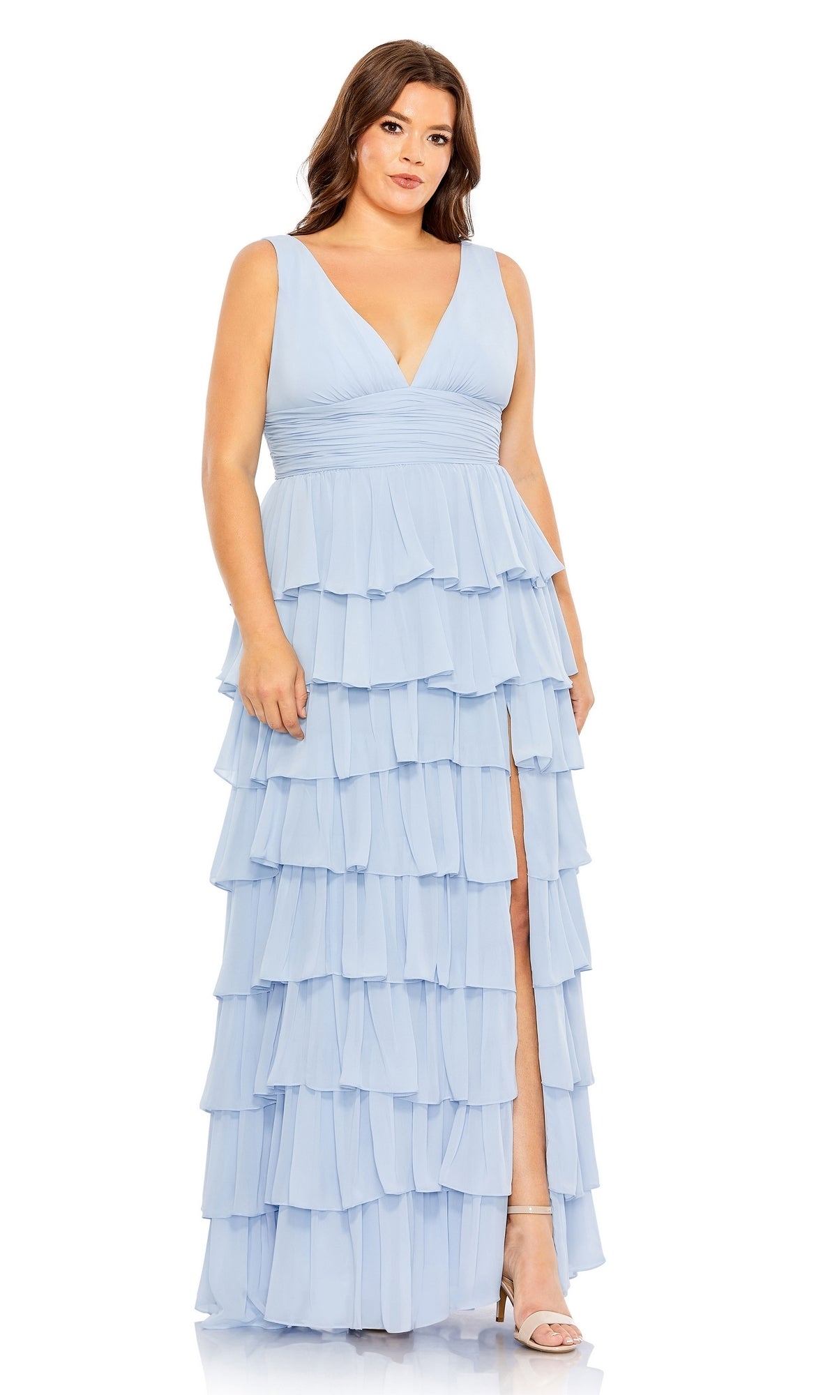 A woman wears the Long Plus-Size Formal Dress 68119 by Mac Duggal, a sleeveless light blue ruffle dress with a ruched empire waist, deep V-neckline, and high slit, paired with light-colored heels.